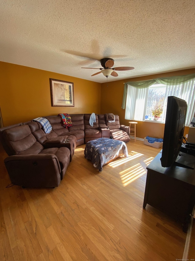 living area featuring a textured ceiling, wood finished floors, and a ceiling fan