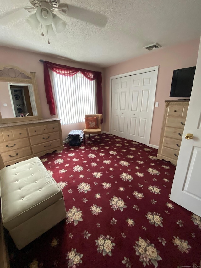 living area featuring a ceiling fan, carpet, visible vents, and a textured ceiling