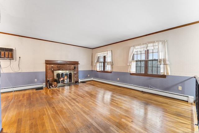 unfurnished living room featuring wallpapered walls, a baseboard heating unit, and wainscoting