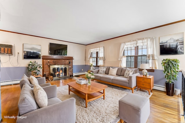 living area with light wood finished floors, a baseboard radiator, and crown molding