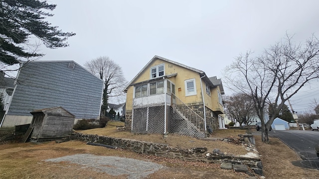 exterior space with an outdoor structure, stairway, and stucco siding