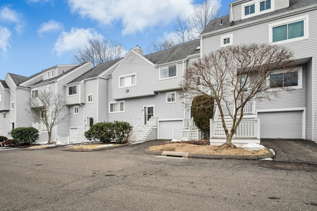 view of front of property with a garage, a residential view, and driveway