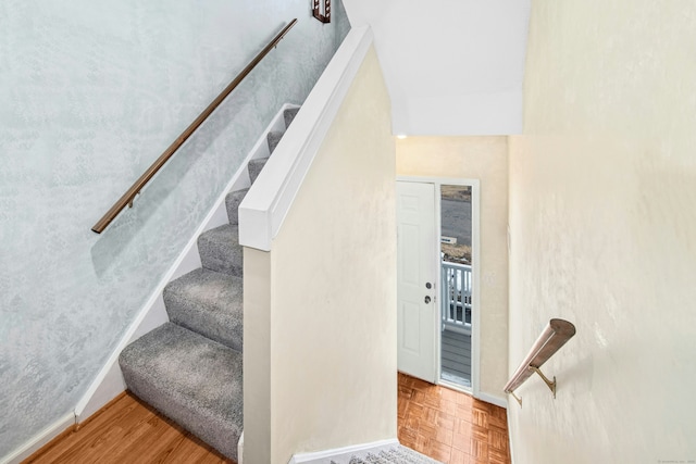 stairway with parquet flooring and baseboards