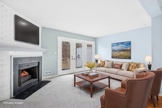 carpeted living room featuring french doors, a premium fireplace, and visible vents