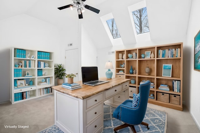 office featuring a skylight, visible vents, light colored carpet, ceiling fan, and high vaulted ceiling