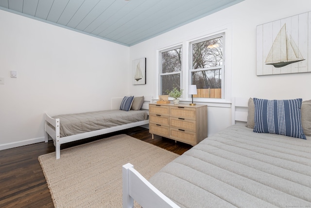 bedroom featuring wooden ceiling, baseboards, and wood finished floors