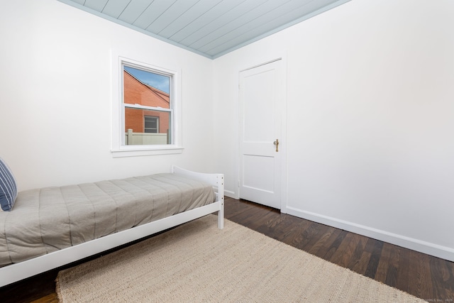 bedroom featuring baseboards and dark wood finished floors