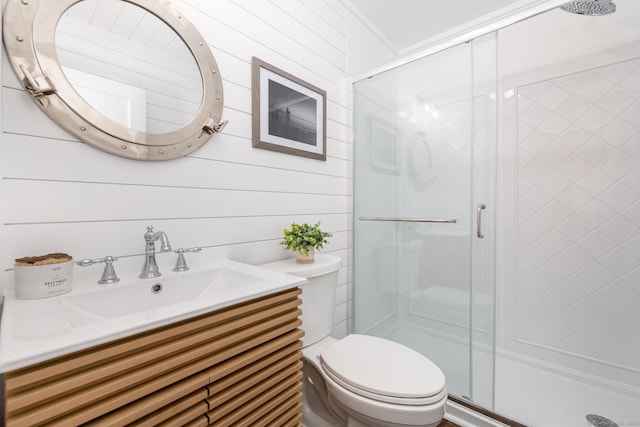 bathroom featuring a shower stall, toilet, and vanity