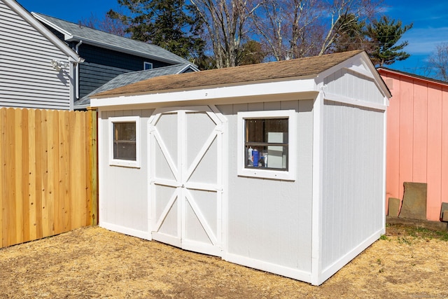 view of shed featuring fence