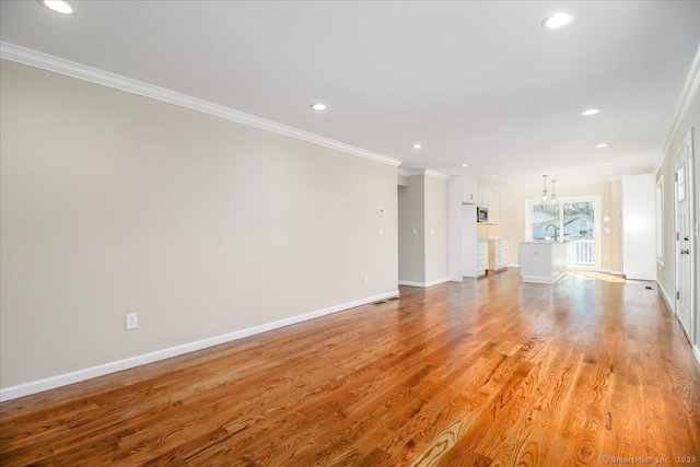 unfurnished room with ornamental molding, recessed lighting, light wood-style flooring, and baseboards