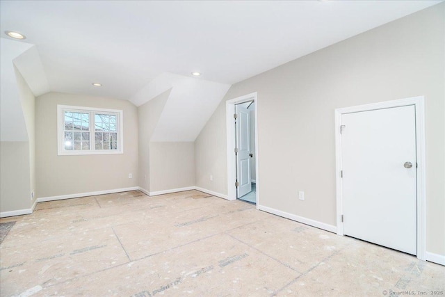 additional living space featuring baseboards, vaulted ceiling, and recessed lighting