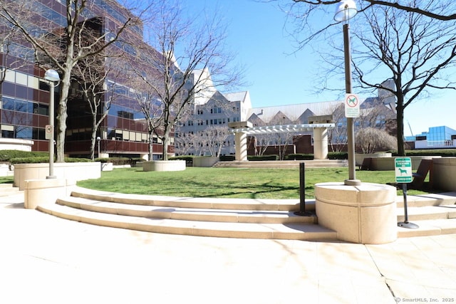 view of home's community featuring a lawn and a pergola