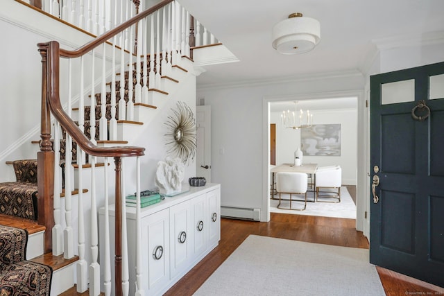 entryway with a chandelier, a baseboard radiator, stairs, dark wood finished floors, and crown molding