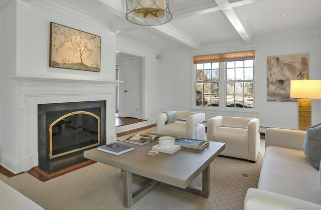 living room with beamed ceiling, coffered ceiling, a glass covered fireplace, and crown molding