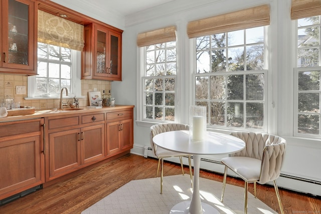 interior space with breakfast area, wood finished floors, and crown molding