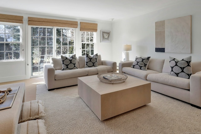 living room featuring ornamental molding, light carpet, and baseboards