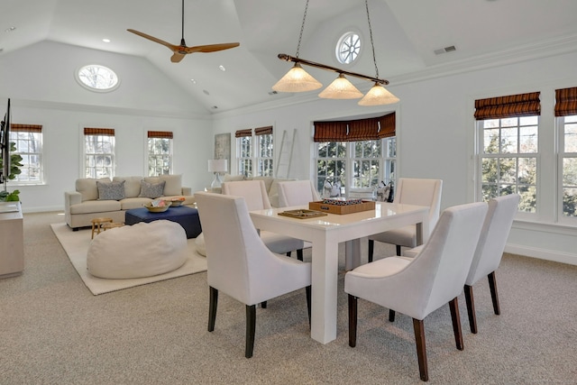 carpeted dining area with high vaulted ceiling, plenty of natural light, visible vents, and baseboards