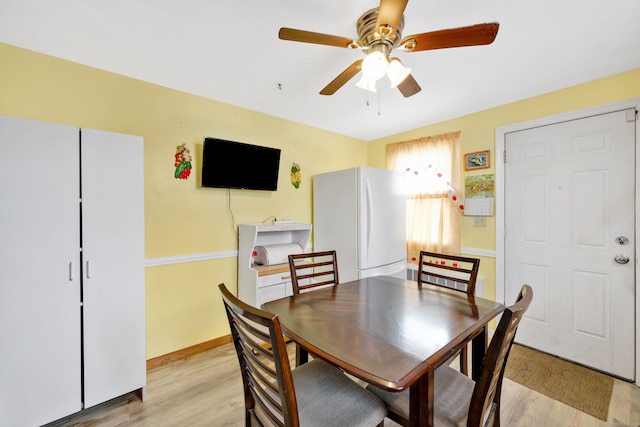 dining space featuring baseboards, light wood-style flooring, and a ceiling fan