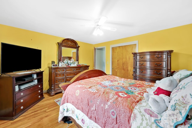 bedroom with a ceiling fan, light wood-style floors, and a closet