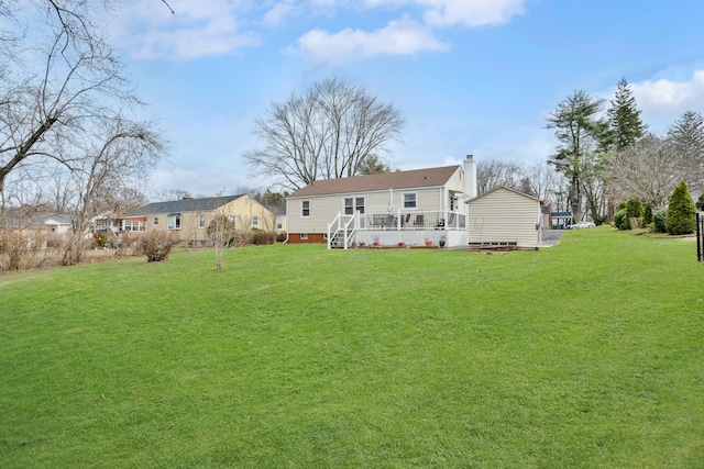 rear view of property featuring a chimney and a yard