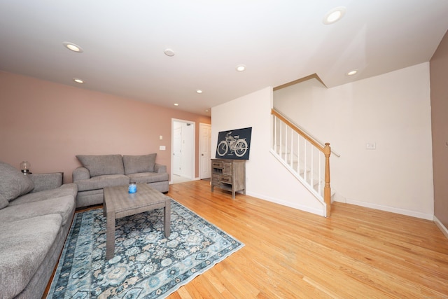 living area featuring recessed lighting, light wood-style flooring, baseboards, and stairs