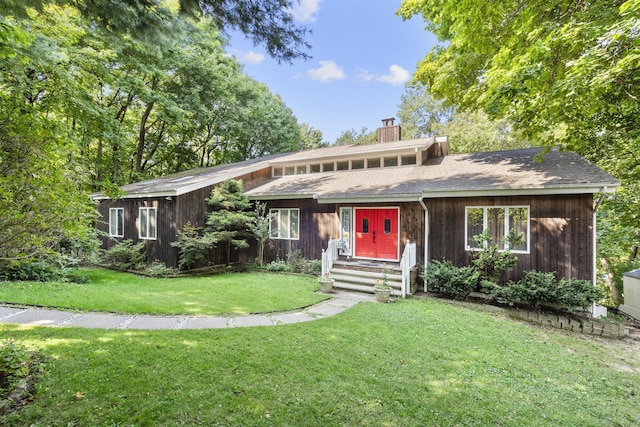 view of front of home with a chimney and a front yard