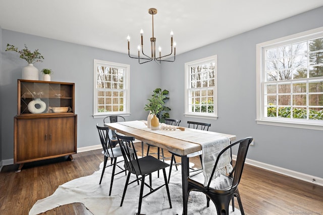 dining area with baseboards, a chandelier, and wood finished floors