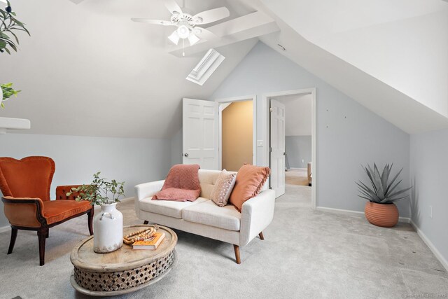 living area with lofted ceiling with skylight, light colored carpet, baseboards, and a ceiling fan