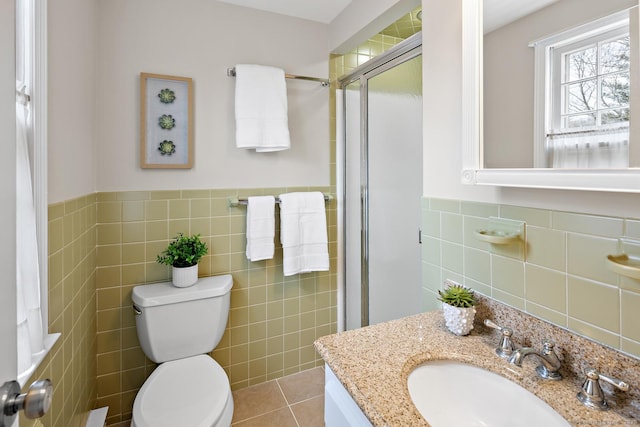 full bathroom featuring tile walls, toilet, vanity, a shower stall, and tile patterned floors