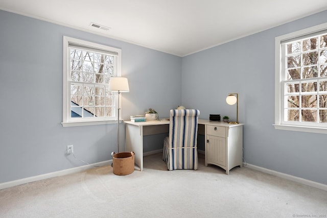 office with a wealth of natural light, visible vents, light carpet, and baseboards