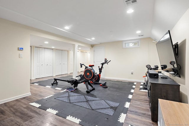 exercise room featuring recessed lighting, wood finished floors, visible vents, and baseboards