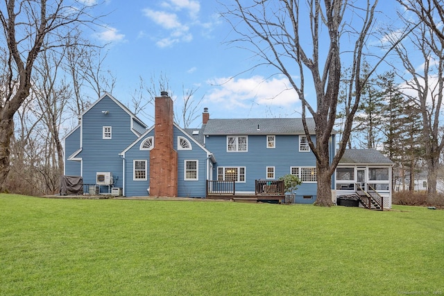 back of house with a chimney, a shingled roof, a lawn, a sunroom, and a deck