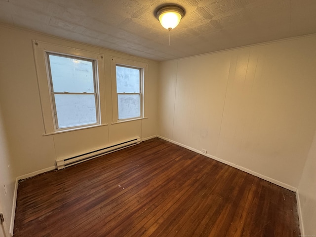 empty room featuring baseboard heating, dark wood finished floors, and baseboards