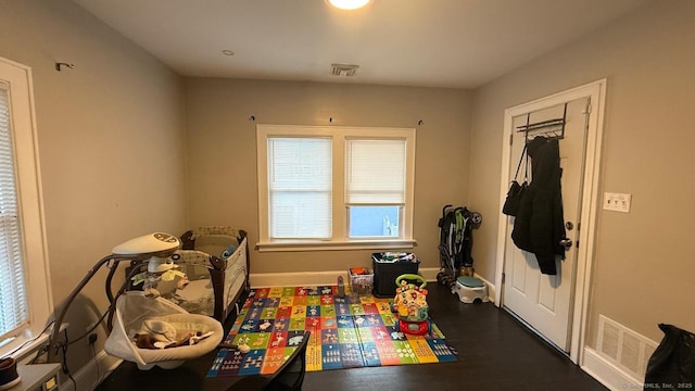 playroom with dark wood-style floors, baseboards, and visible vents