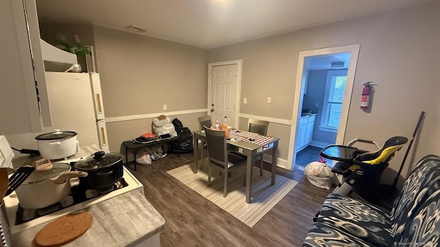 dining area with dark wood-type flooring and visible vents