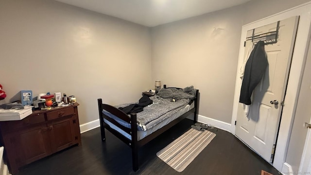 bedroom featuring baseboards and dark wood finished floors