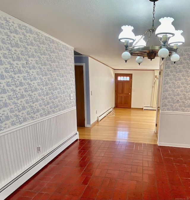 foyer with a baseboard heating unit, a wainscoted wall, and wallpapered walls