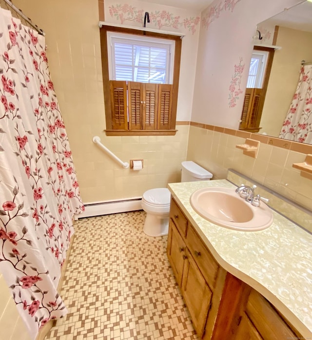 full bathroom featuring toilet, a wainscoted wall, vanity, baseboard heating, and tile patterned floors