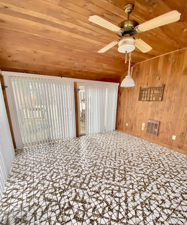 unfurnished room featuring a ceiling fan, wood ceiling, visible vents, and wood walls