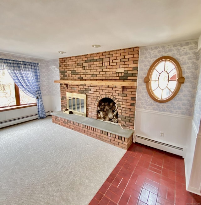 unfurnished living room featuring baseboard heating, wainscoting, a fireplace, and wallpapered walls