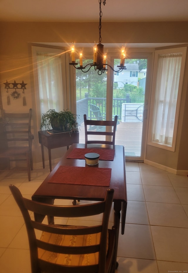 dining area with a notable chandelier, baseboards, and light tile patterned floors