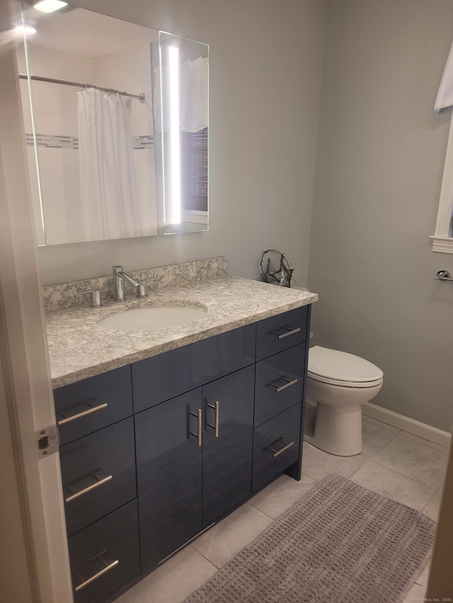 full bathroom with curtained shower, tile patterned flooring, toilet, vanity, and baseboards