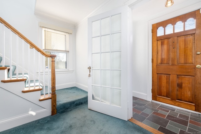 foyer featuring stairs, carpet flooring, baseboards, and ornamental molding