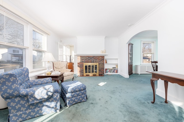 carpeted living room featuring baseboards, a fireplace, arched walkways, and ornamental molding