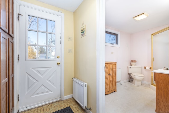 doorway with baseboards and radiator