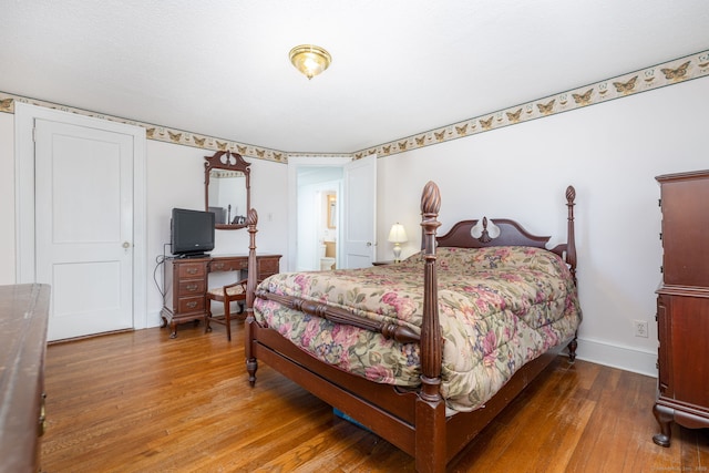 bedroom with baseboards and wood finished floors