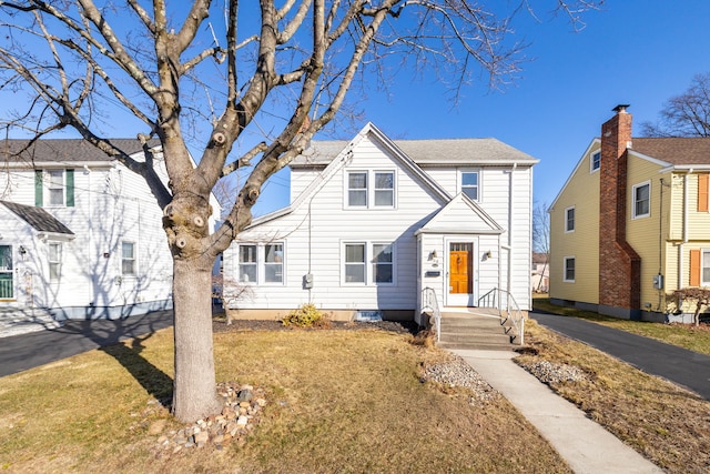 view of front of home with aphalt driveway and a front yard