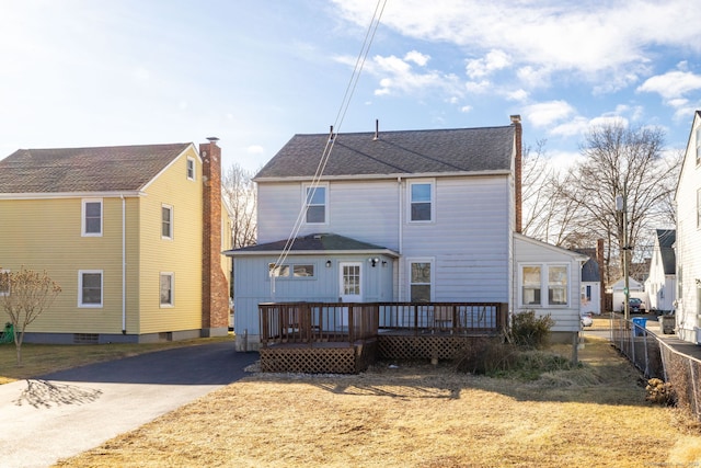 back of house featuring fence, driveway, and a wooden deck