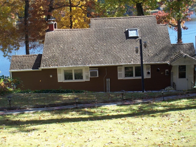 view of home's exterior featuring a lawn and roof with shingles