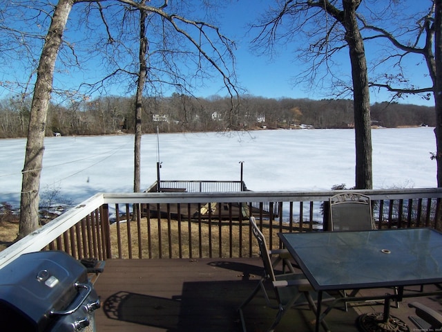 snow covered deck featuring area for grilling and outdoor dining space